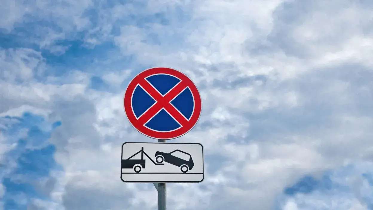Sinal de trânsito que indica proibição de estacionamento com aviso de reboque de veículos