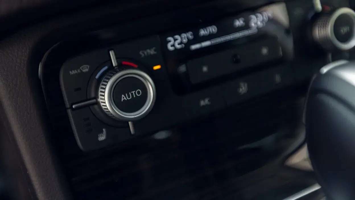 Painel de controlo do ar condicionado automático de um carro com temperatura ajustada a 22ºC.