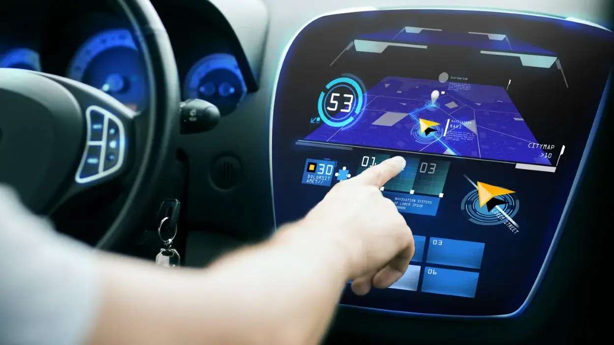 Mão a interagir com ecrã tátil de navegação num carro moderno