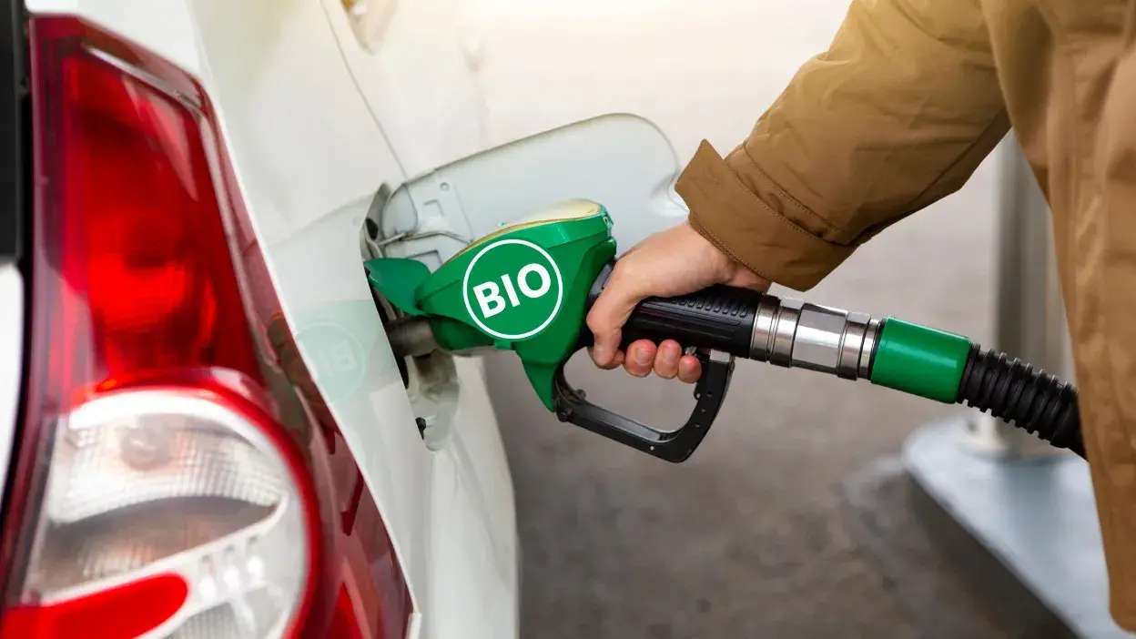 Pessoa a abastecer carro com biocombustível numa bomba verde marcada com "BIO"