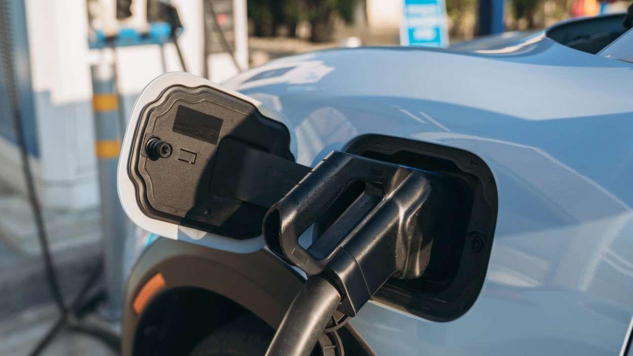 carro elétrico azul bebé a carregar em estação de carregamento pública